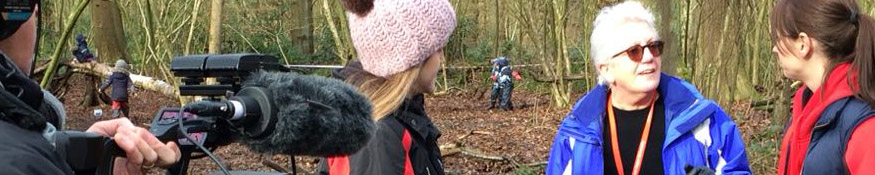 Banner image of academics being interviews in a forest